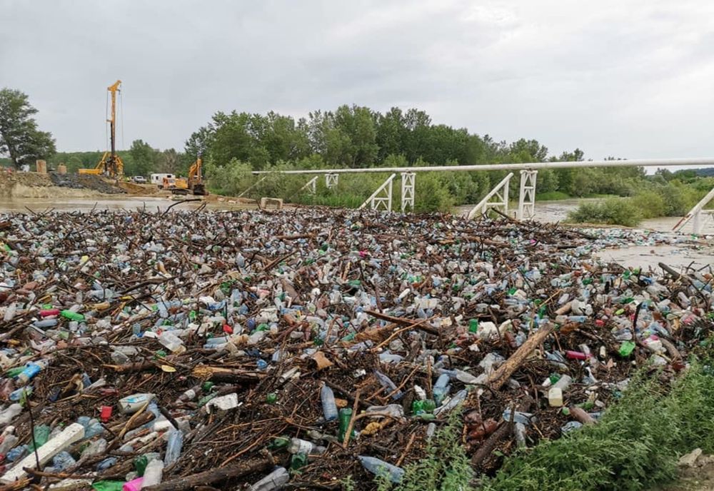 VIDEO IREAL. Baraj din PET-uri aduse de viitură, pe râul Olteţ
